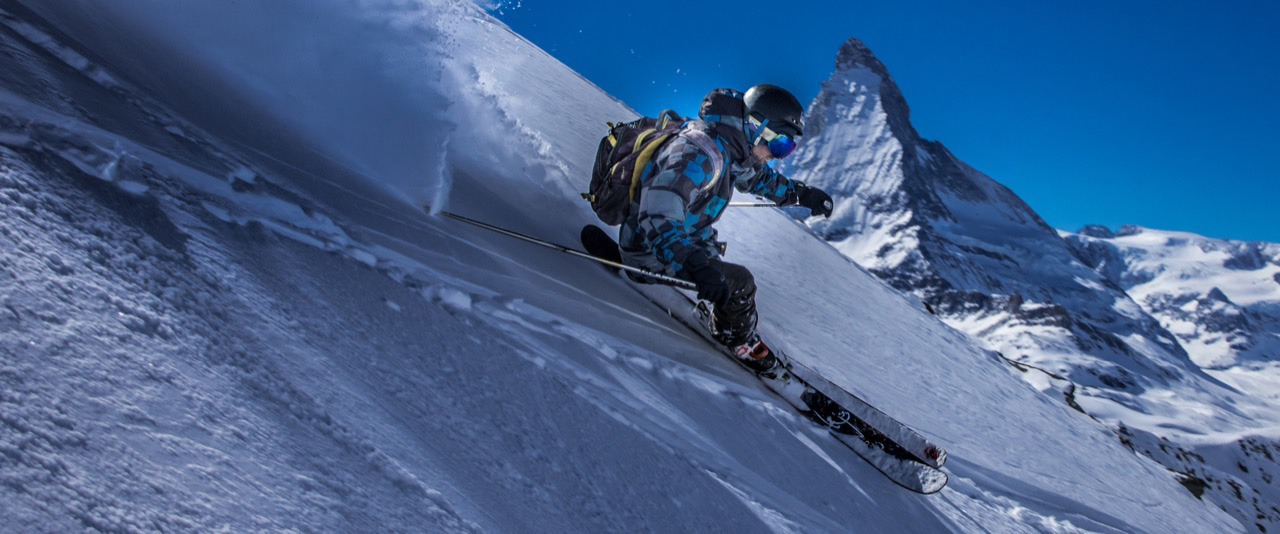 Maestro di sci che sta sciando fuoripista con il Cervino sullo sfondo