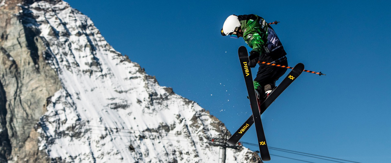 Skilehrer bei einem Trick namens 360 tail grab