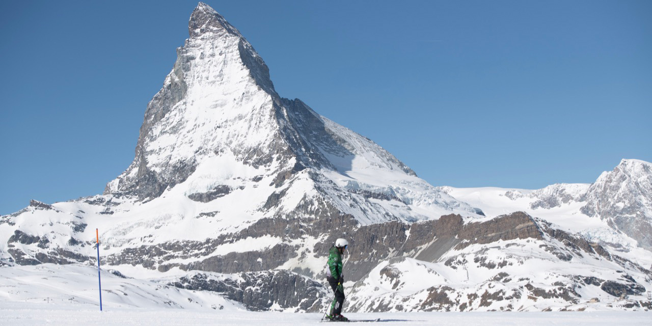 Skilehrer stehend mit Skiern und dem Matterhorn im Hintergrund