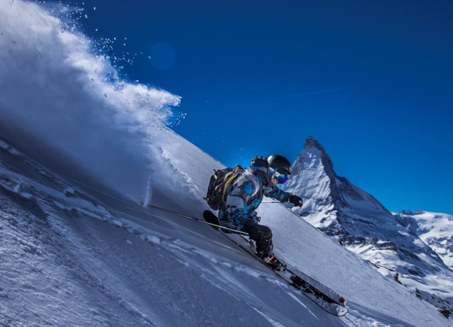 Instructor de esquí esquiando fuera de pista con el Matterhorn de fondo